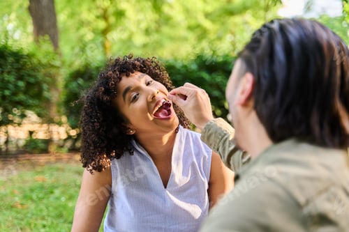 Preview: Couple sharing cherries in a park, enjoying summer romance