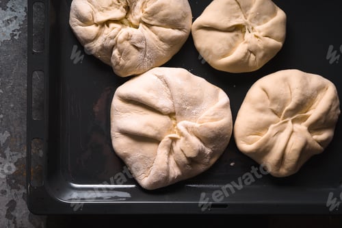 Preview: Khachapuri with cheese on a baking sheet on a metal background closeup