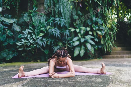Preview: flexible woman in tracksuit stretching muscles during sportive yoga workout outdoors