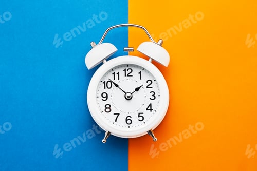 Preview: White vintage alarm clock on blue-orange background. Top view, copy space. Daylight saving concept.