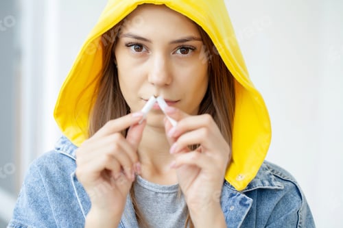 Preview: Stop smoking, woman holding a broken cigarette in her hand