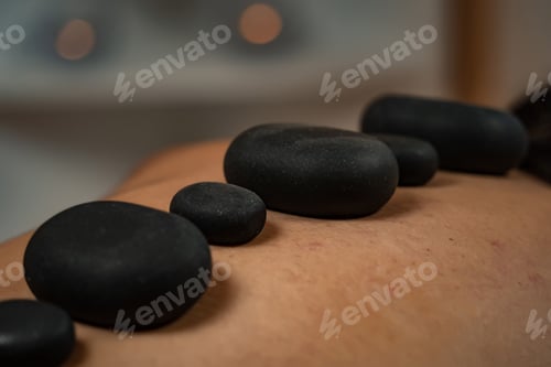 Preview: Female customer is receiving a relaxing spa treatment of hot stone massage