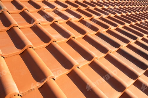 Preview: Overlapping rows of yellow ceramic roofing tiles covering residential building roof
