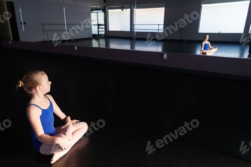 Preview: Young girl sitting cross legged on floor of dance studio alone