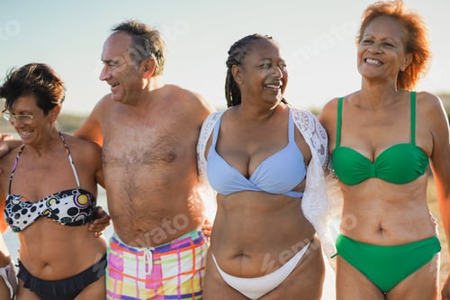 Preview: Multiracial senior people having fun walking on the beach during summer vacation