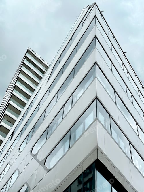 Preview: View To Top Of Glass Modern Triangle Architecture Building on Grey Gloomy Cloudy Sky Background