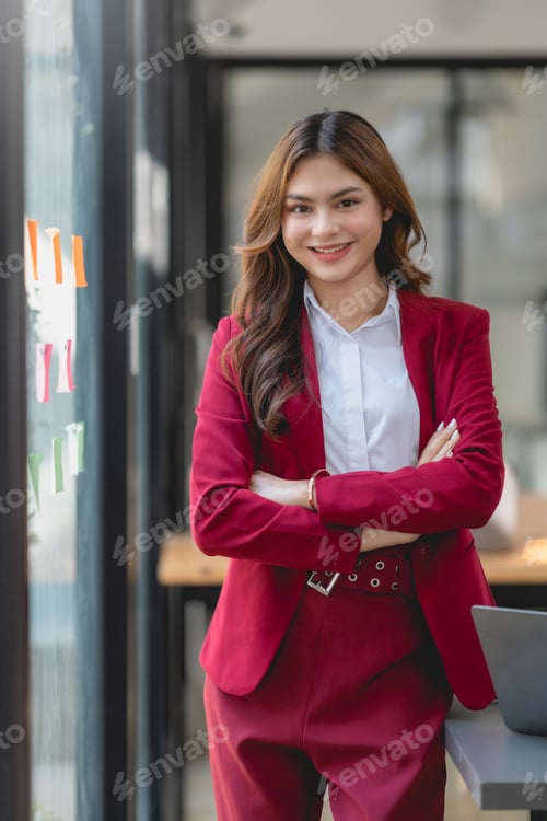 Preview: Smiling Confident Businesswoman With Arms Crossed Standing In Office.