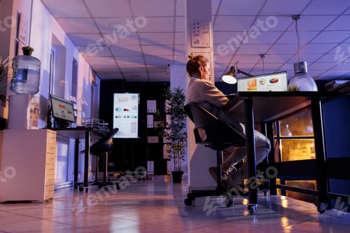 Preview: Businesswoman sitting at desk table in startup office
