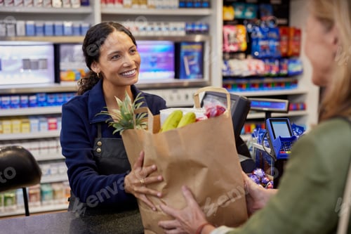 Preview: Happy cashier at the supermarket serving client