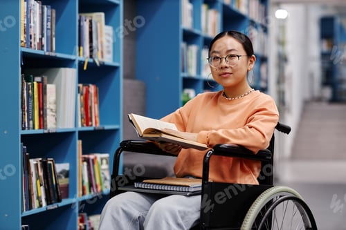 Preview: Asian young woman with disability in library smiling at camera