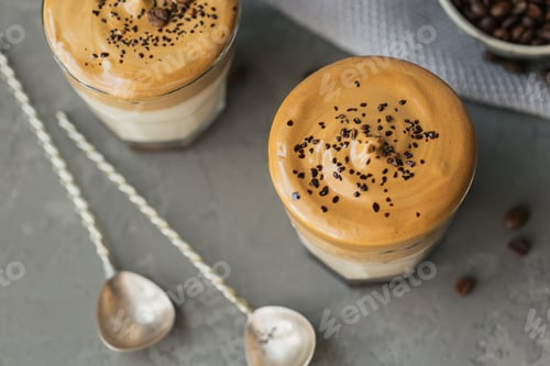 Preview: Glass of Iced Dalgona Coffee, trendy fluffy creamy whipped coffee and milk on grey background.