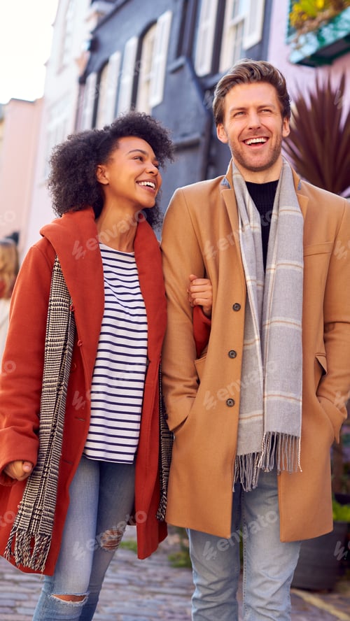 Preview: Multi Cultural Couple With Friends Walking Along Residential City Street In Fall Or Winter