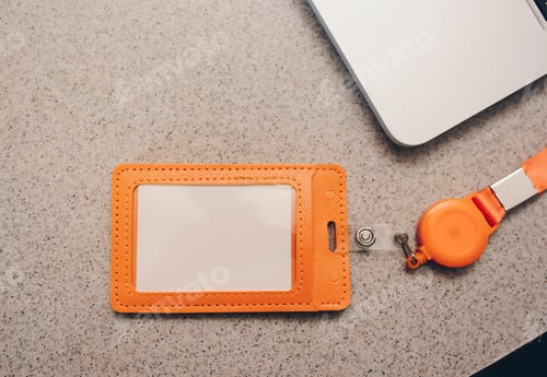 Preview: Orange badge with strap on marble table