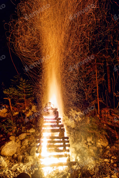 Preview: Vertical image of a large, blazing bonfire, with bright orange and yellow flames