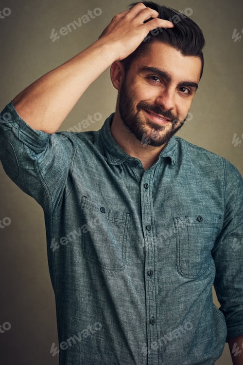 Preview: Studio shot of a handsome young man posing with his hand in hair