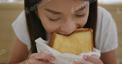 Preview: Woman eat sandwich toast at restaurant