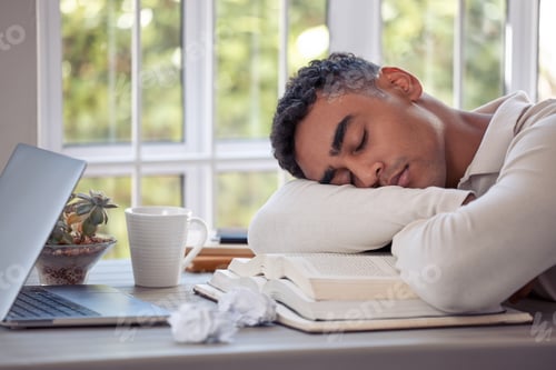 Preview: Find your balance. Shot of a young male sleeping on the table at home.