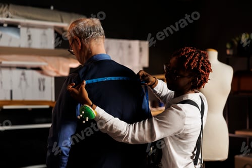 Preview: Woman Tailor Measuring Man's Vest in Studio