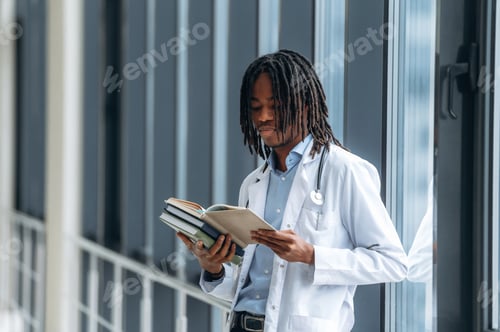 Preview: Lot of learning material, holding books. Young male black doctor is in the corridor