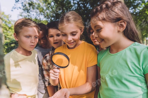 Preview: selective focus of multicultural kids looking through magnifier in park