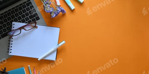 Preview: Laptop putting on colorful desk surrounded by notebook, pen, flowers, marker pens and pencil.