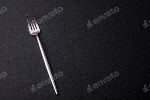 Preview: Metal kitchen fork on a dark textured concrete background