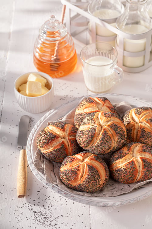 Preview: Tasty Kaiser buns with poppy seed in white basket.