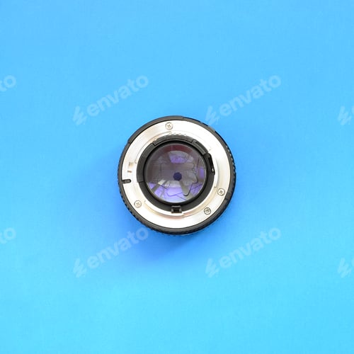 Preview: One photographic lense lie on a bright blue background. Space for text