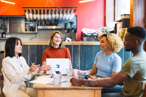 Preview: Diverse group of young professionals having a discussion in a modern cafe