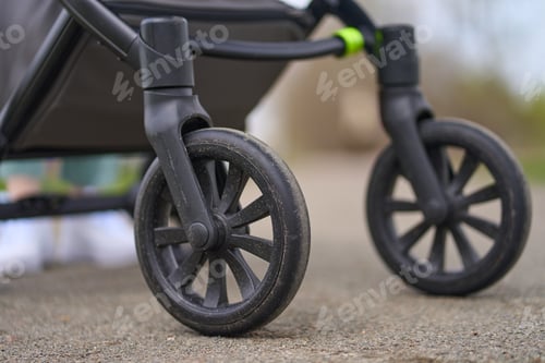 Preview: Wheels of a baby carriage close-up on a background of asphalt, wheels go on the road