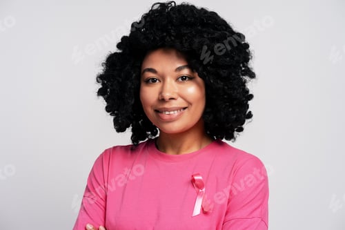 Preview: Smiling woman wearing pink ribbon supporting breast cancer awareness
