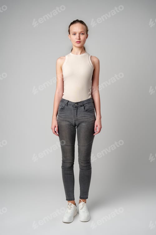 Preview: Girl in Beige Tank Top and Grey Jeans on gray background