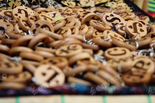 Preview: Closeup shot of many wooden keychains with different letters and heart shapes on them