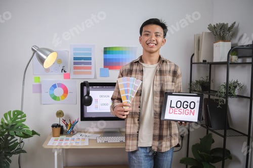 Preview: Young Professional With Tablet in Hand Showing His Approval of Digital Logo Concept on Bright Screen