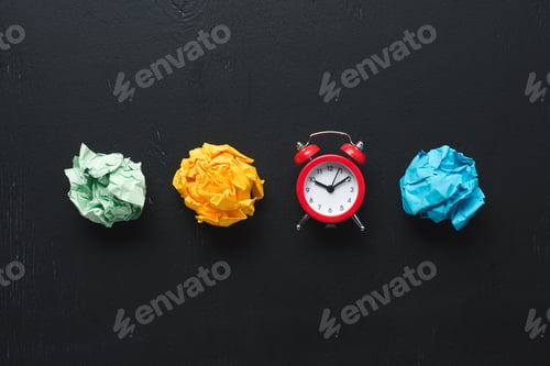 Preview: top view of colorful crumpled paper balls and clock on black background, time management concept