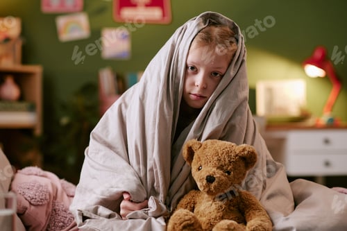 Preview: Portrait of Girl Child Sitting Wrapped in Blanket Holding Toy Bear