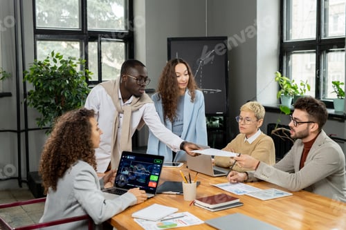 Preview: African businessman passing paper to one of colleagues