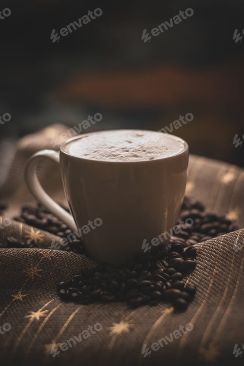 Preview: Vertical shot of a cup of coffee and beans on a piece of fabric