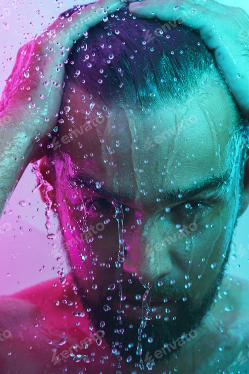 Preview: Portrait of handsome man under water flow in neon light
