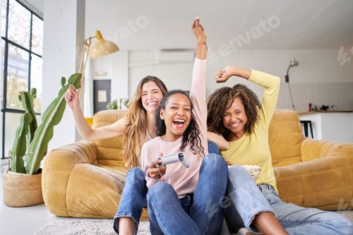 Preview: Group of young female multiracial young friends play video games together at home