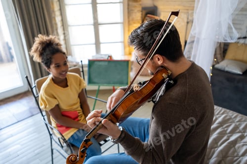 Preview: Man Playing Violin for a Young Girl Indoors