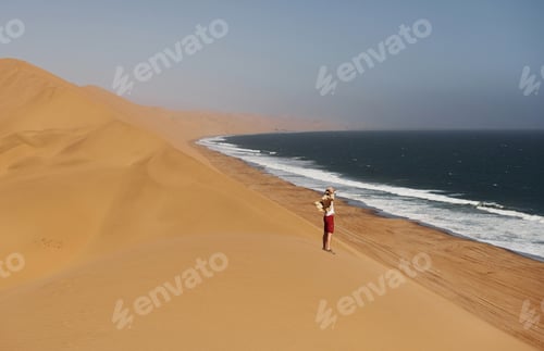 Preview: Clear blue sky. Tourist is walking on the sand near the sea