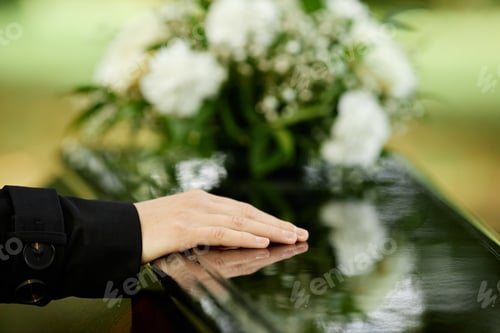 Preview: Close up of female hand on coffin