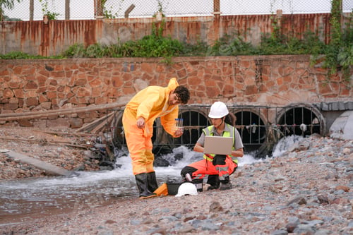 Preview: environmental researchers walk back from shoreline testing. They carry safety