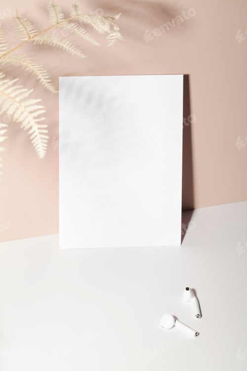 Preview: paper card note with headphones on beige background with shadow and fern. copy space.