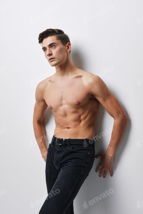 Preview: sporty man in jeans stands near the wall indoors