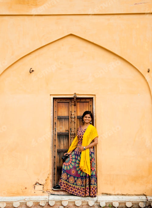 Preview: Woman tourist in front of old door at Amber fort, Jaipur, India