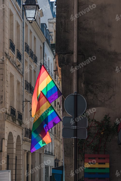 Preview: LGBTQ flags on corner of old building in Paris during pride. Transgender Pride flag