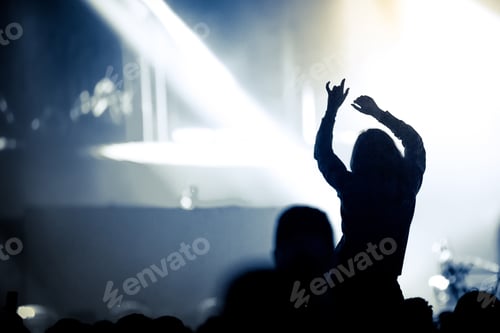 Preview: Woman with arms outstretched at concert. Summer music festival concept
