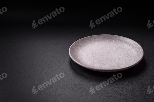 Preview: Empty ceramic round plate on dark textured concrete background